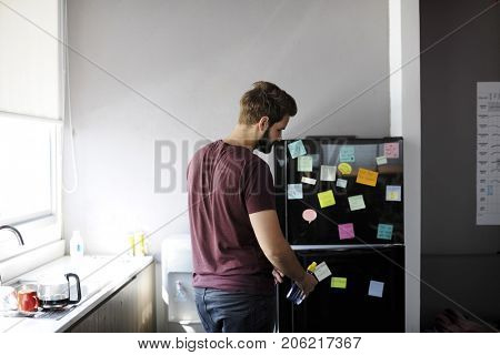 Man Taking Water Bottle From Fridge in Pantry Room During Break Time