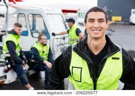 Confident Worker Smiling While Colleagues Communicating At Gangw