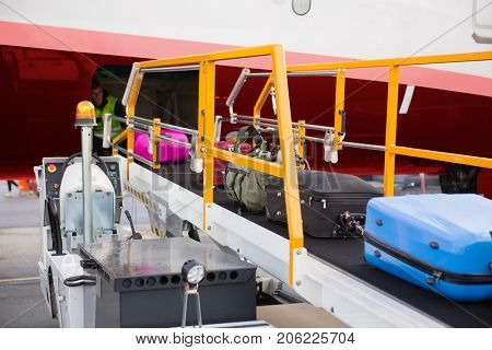 Suitcases On Moving Conveyor Attached To Airplane
