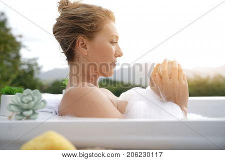 Beautiful woman in bath and using nailbrush