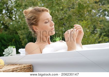 Beautiful woman in bath and using nailbrush