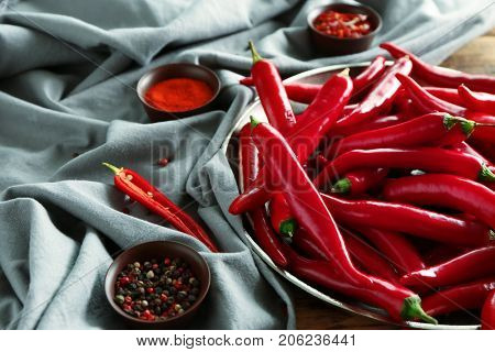 Plate with red chili peppers on table