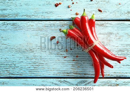 Tied red chili peppers on wooden background