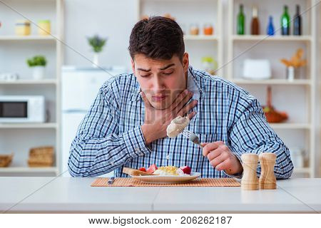 Man eating tasteless food at home for lunch