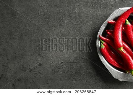 Plate with red chili peppers on gray table