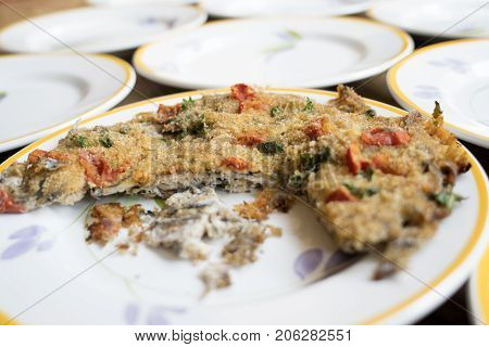 baked anchovy pie au gratin between a series of white dishes
