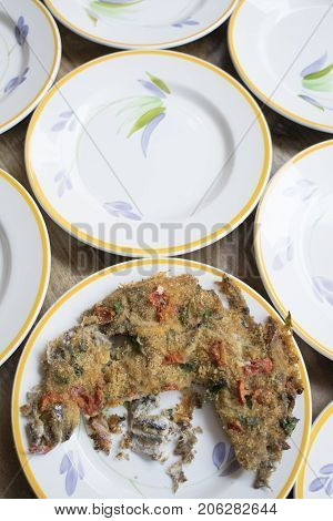 baked anchovy pie au gratin between a series of white dishes