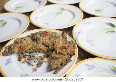 baked anchovy pie au gratin between a series of white dishes