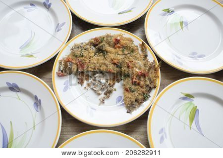 baked anchovy pie au gratin between a series of white dishes