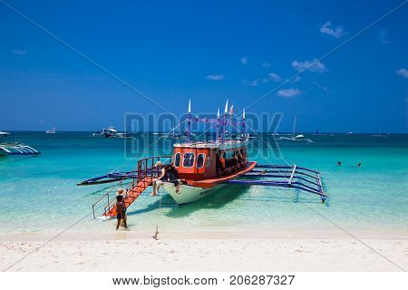 BORACAY, PHILIPHINES-MART 19, 2017: Tourists in tourst's boat at famous White Beach on March 19, 2017. Boracay Island, Philippines.