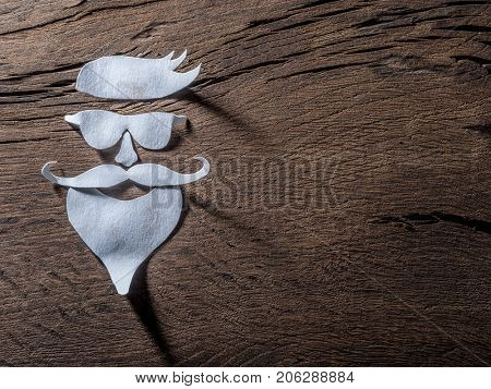 Hipster's definicial facial look cut from paper on the wooden background.