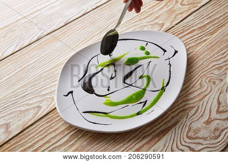 Modern cuisine chef preparation with creamy spots Molecular gastonomy