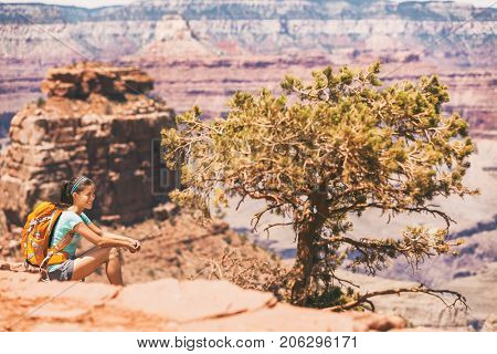 Grand Canyon hiker woman resting on desert hike. Hiking Asian girl relaxing on South Kaibab Trail, south rim of Grand Canyon, Arizona, USA.