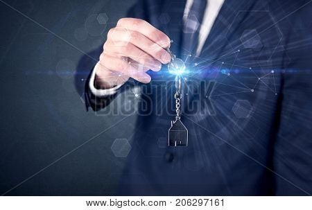 Businessman in suit holding over a key with connection concept around
