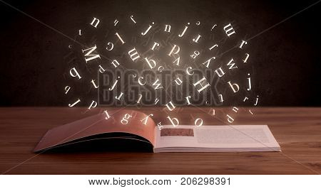 Glowing white alphabet letters coming out of an open book