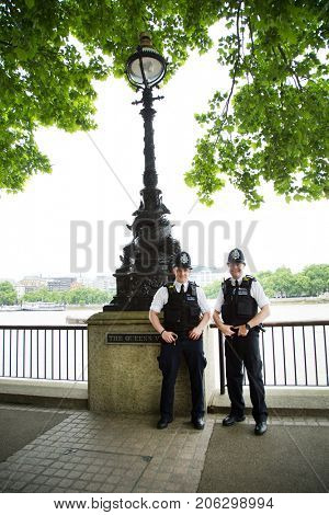 LONDON-UK, May 29, 2017:  Two policeman smilling, the British police, popularly known as âbobbies,â wear a uniform that is nonmilitary in appearance. Their only regular weapon is a wooden truncheon.