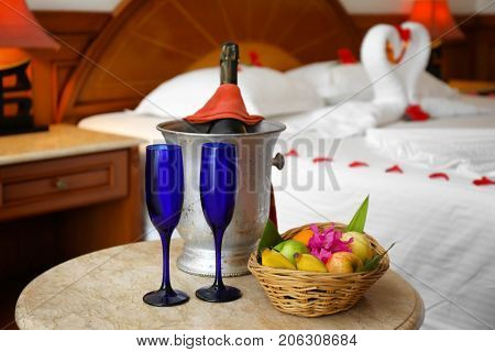 Fruits and champagne in hotel room prepared for romantic date