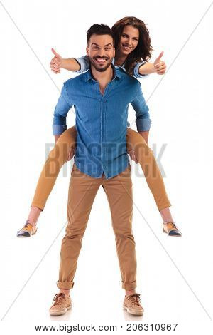casual woman on the back of her man making the ok thumbs up sign on white background