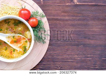 White soup noodles with tomatoes. Potatoes, dill, spices. On a wooden Board.