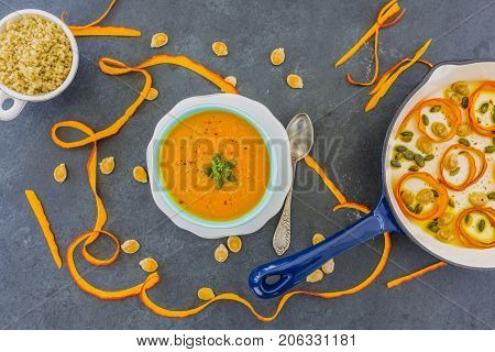 Delicious pumpkin soup and quinoa seeds on dark background.