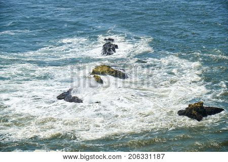 Rocks And Waves Of Surf In The Ocean Near Farol De Nazare Coast In Portugal