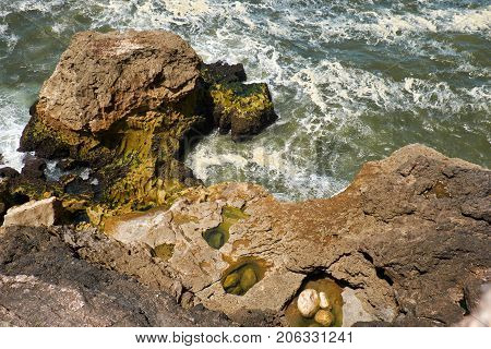 Rocks And Waves Of Surf In The Ocean Near Farol De Nazare Coast In Portugal