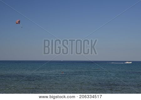 Parasailer and a boat against blue sky and sea and horizonpicture from Thassos Island Greece.