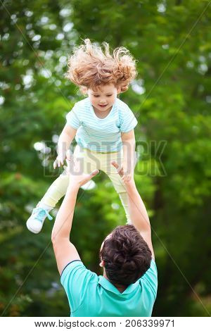Father and daughter having fun in the park. Fatherhood caring single father family relationships and friendship. Toddler girl loving her daddy. Summer day.