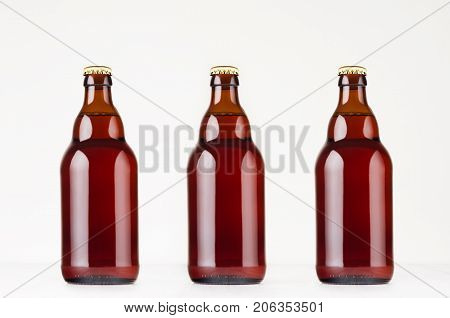 Set of brown steinie belgian beer bottles 330ml mock up. Template for advertising design branding identity on white wood table.
