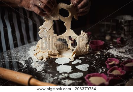 Man makes dough from flour and eggs on a glass table