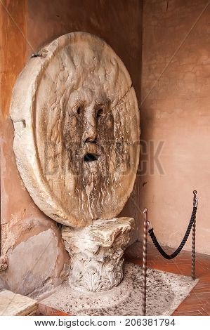 The Mouth of Truth (La Bocca della Verita) carved from Pavonazzo marble in the portico of the church of Santa Maria in Cosmedin in Rome Italy