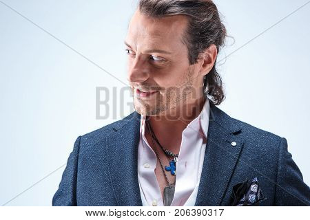 The mature bearded man in a suit holding cane. Isolated on a blue studio background.