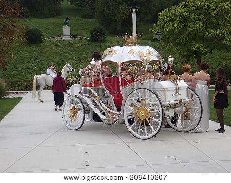 Princess riding a white horse and a coach with a retinue