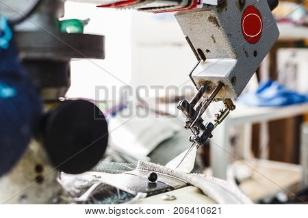 Overlock sewing machine - view on working area and machine front with needle - foreground blanked ot blurry.
