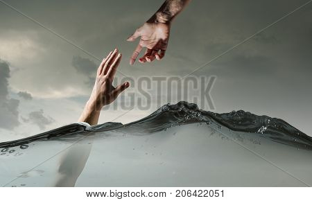 Hand of person drowning in water