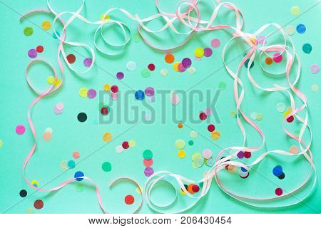 Festive party or carnival confetti on a mint color background with copy space