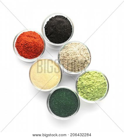 Different colorful superfood powders in bowls on white background