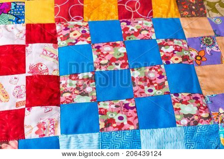 garment industry, needlework, homemade, quilting, interior, design concept - masterpiece of sewing made of colorful textile scraps in geometric forms with various ornaments