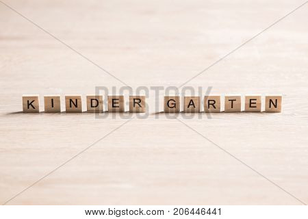 Alphabet letters on wooden pieces collected to word kinder garten