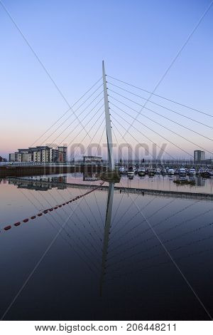 Millennium Bridge at Swansea Marina. Vertical format at dusk with calm waters.