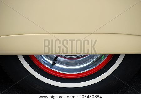 Vintage car skirts and classic whitewall tire displayed outdoors.