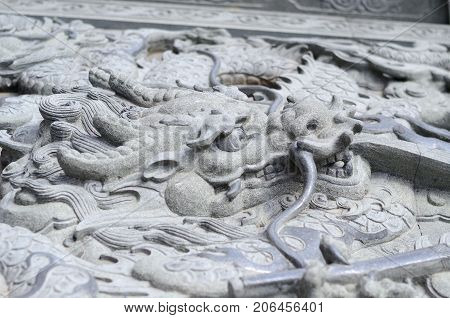 The gabel end of an Asian designed building with a dragon statue