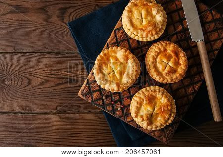 Mini Meat Pies From Flaky Dough On A Wooden Board Over Wooden Background.