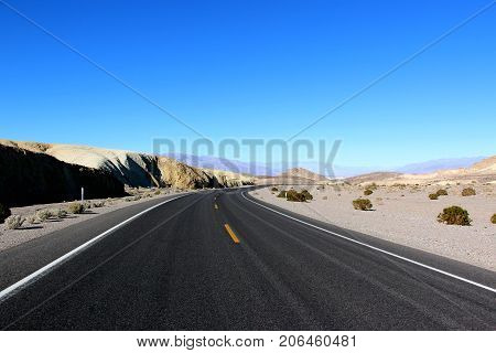 Road in the Death Valley National Park with blue sky background, California.