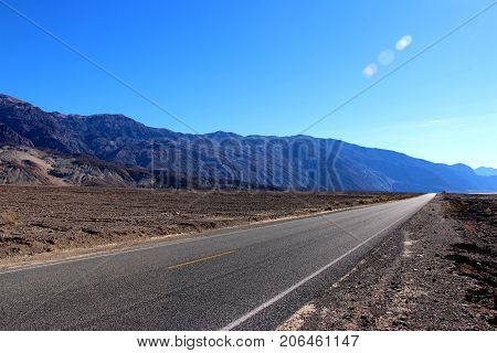 Road in the Death Valley National Park with colorful sky background, California.