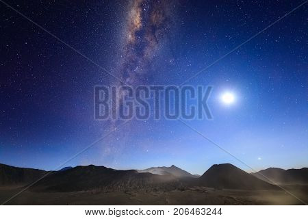 Bromo volcano with milky way the moon and sand strom Tengger Semeru national park East Java Indonesia