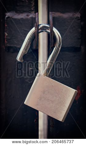 Unlocked Padlock on a Rusty Iron Gate
