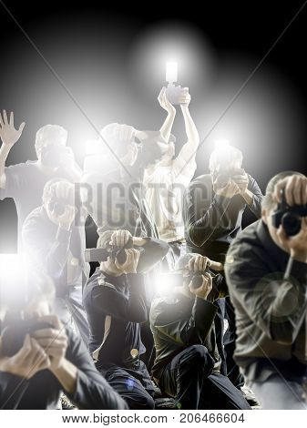 Crowd of paparazzi flashing in front a dark black background.
