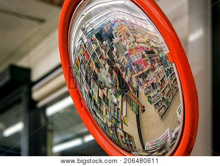 BANGKOK THAILAND - August 27: Convex mirror shows an unidentified customer with an unidentified cashier in a 7-Eleven convenient store on August 27 2017 in Bangkok.