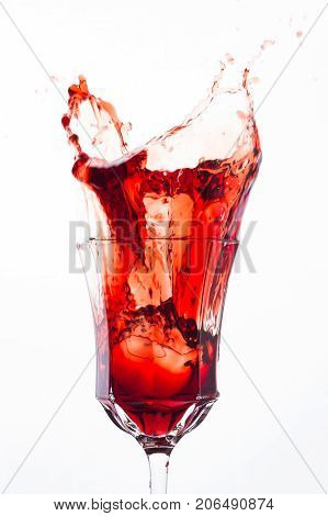 Glass of splash red wine on white background